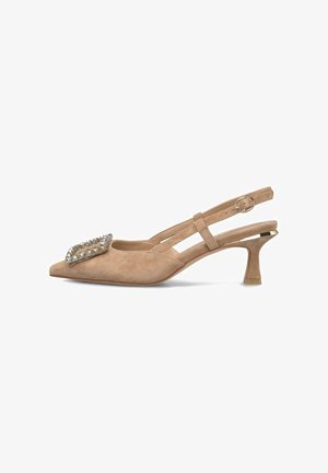 Tacón slingback de ante beige con puntera afilada, decorado con un acento de cristal en tono plateado. Presenta un tacón de aguja delgado y corto.