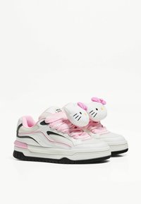 Białe sneakersy z różowymi sznurowadłami i akcentami, z aplikacjami głowy Hello Kitty na sznurowadłach. Teksturowana siateczka i gumowa podeszwa.