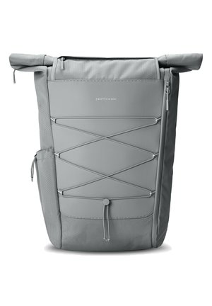 Mochila gris con tapa enrollable que presenta un tejido texturizado, diseño de cordón elástico frontal, bolsillo lateral y cierre de cremallera.