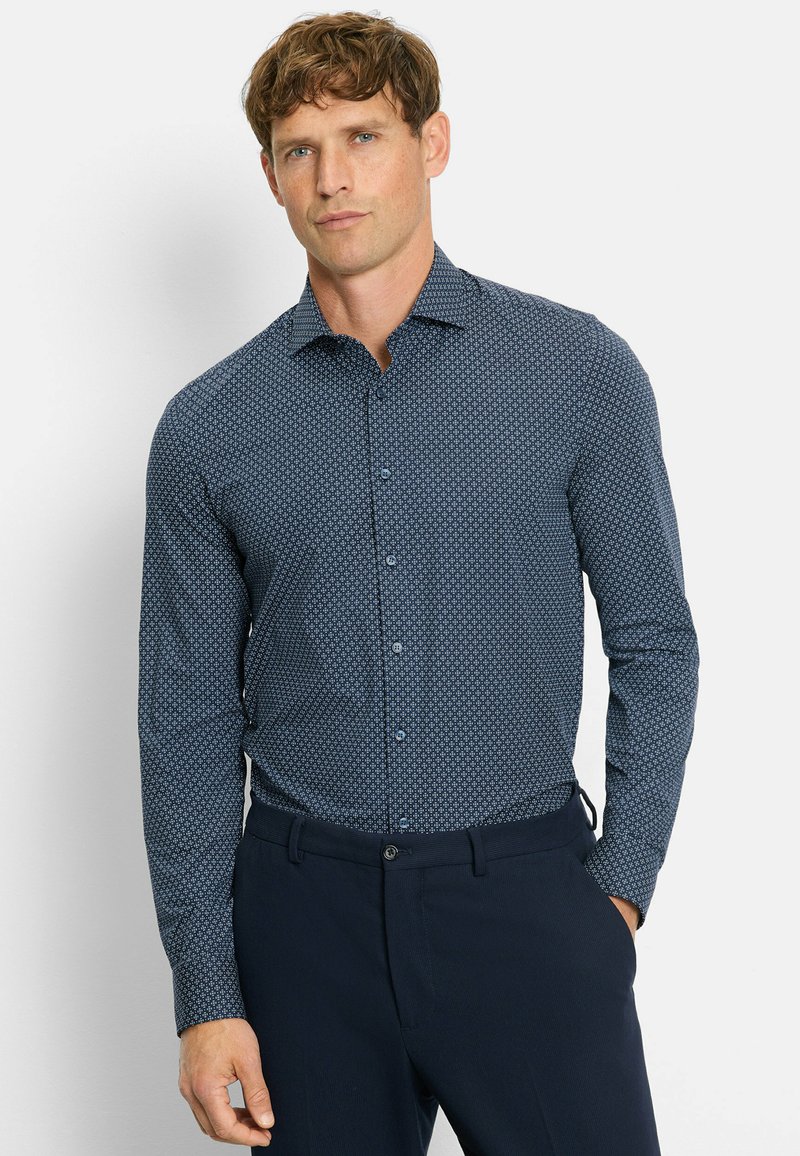Marineblaues Hemd mit kleinen weißen geometrischen Mustern, langen Ärmeln, Knopfverschluss und schmalem Kragen. Glatte Stofftextur.