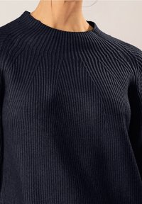Granatowy prążkowany sweter z wysokim kołnierzem, teksturowaną tkaniną i ukośnymi wzorami ściegów na klatce piersiowej. Miękki, dopasowany krój.