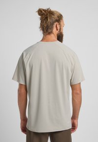 Lichtgrijs sportshirt gemaakt van glad, ademend materiaal. Kenmerkt zich door korte mouwen, een ronde hals en platte naden voor comfort.