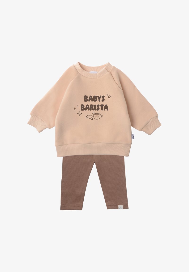 Peach sweatshirt with "BABY'S BARISTA" text, paired with brown ribbed leggings. Soft fabric, long sleeves, and cuffed hems enhance comfort.