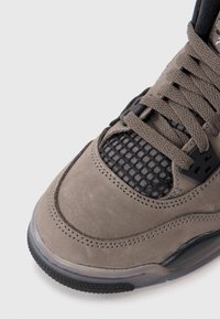 Baskets en suede gris avec des détails en maille, bout rond et lacets plats. Possède des accents noirs et une semelle en caoutchouc avec une texture antidérapante.