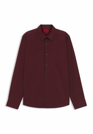 Long-sleeve burgundy shirt made of smooth fabric, featuring a classic collar, black button closures, and stitched logo detail on the hem.
