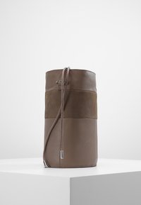 Borsa cilindrica in pelle marrone con una fascia in suede; chiusura a coulisse con dettagli in argento; superfici lisce e testurizzate degne di nota.