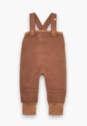 Braune Stoff-Latzhosen mit verstellbaren Trägern, die eine strukturierte Oberfläche und gerippte Knöchelabschlüsse in einem helleren Braun aufweisen. Akzentuiert mit Holzknöpfen.