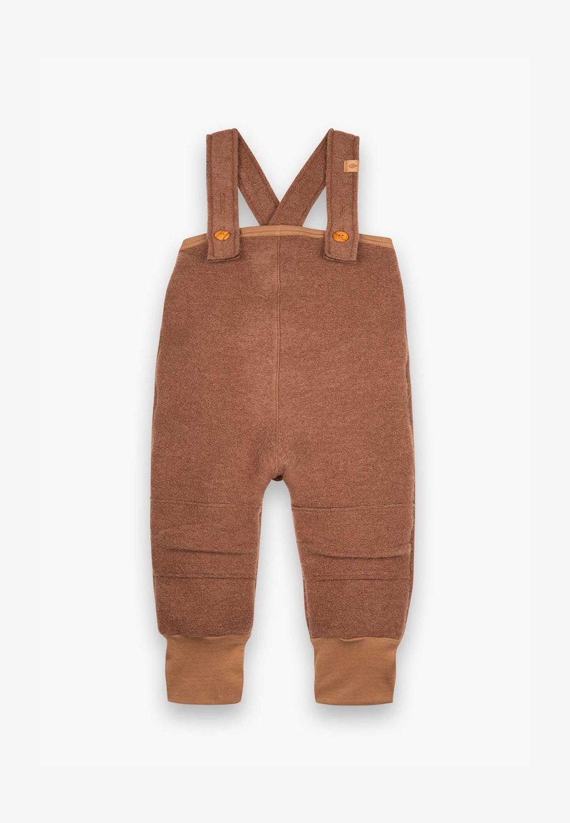 Braune Stoff-Latzhosen mit verstellbaren Trägern, die eine strukturierte Oberfläche und gerippte Knöchelabschlüsse in einem helleren Braun aufweisen. Akzentuiert mit Holzknöpfen.