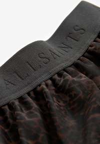 Sort elastisk talje med præget tekst "ALLSAINTS"; letvægtsstof med et mørkt dyreprintmønster.