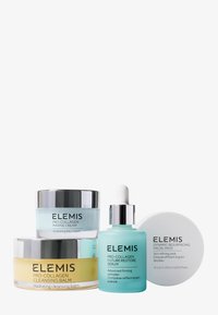 Fire hudpleieprodukter: en gul rensebalsam i krukke, en lys blå serumflaske med pipette, samt krem og ansiktspads, alle med elegante, moderne design.