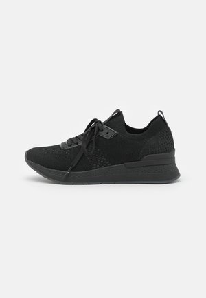 Baskets en maille noire légères avec lacets, semelle rembourrée et détails texturés, vues de l'intérieur sur fond blanc.
