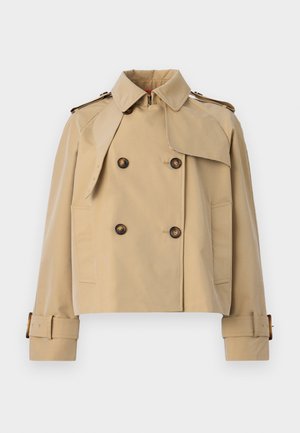 Beige cropped trenchcoat med dobbeltknaplukning, store skulderlapper og bæltestropper ved ærmerne. Lavet af glat, let stof.