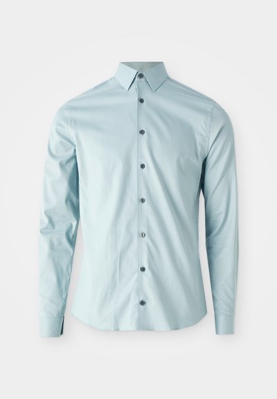 Lyseblå langermet skjorte laget av glatt stoff, med spiss krage og seks mørke knapper foran.
