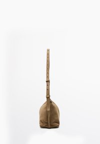 Sac à main en daim marron avec une bandoulière réglable, posé debout sur un fond blanc.