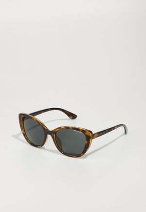 Tortoiseshell sunglasses with a cat-eye shape, gray lenses, and dark brown accents. Features engraved brand name on the temple.