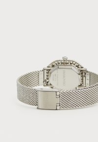 Ceas cu brățară din plasă de argint, carcasă octagonală, finisaj texturat și cataramă cu gravura "SWAROVSKI" pe spate.