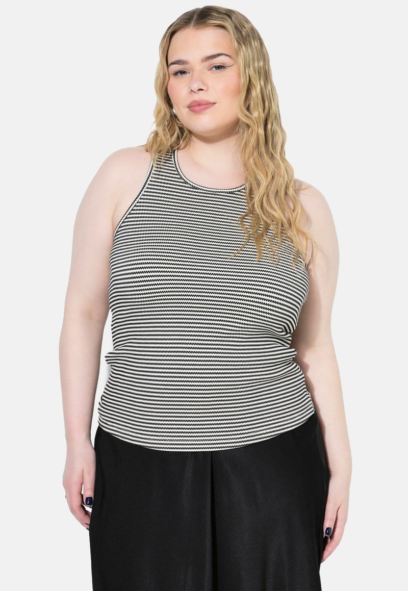 Randig, ärmlös topp i svart och vitt, tillverkad av ett elastiskt material. Åtsittande design med rund halsringning och slät textur.