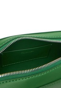 Interno di una borsa in pelle verde con una cerniera argentata e rivestimento in tessuto coordinato. Presenta uno slot per carte e una texture liscia.