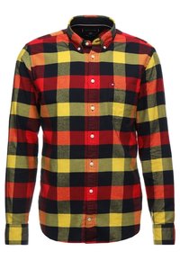 Rood, geel en groen geruit overhemd met lange mouwen. Met knopen te sluiten kraag en een enkele borstzak met een klein logo. Zachte katoenen stof.