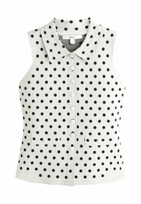 Ærmeløs vest i hvid med sorte polkaprikker, med krave, frontknapper og to små lommer ved taljen.