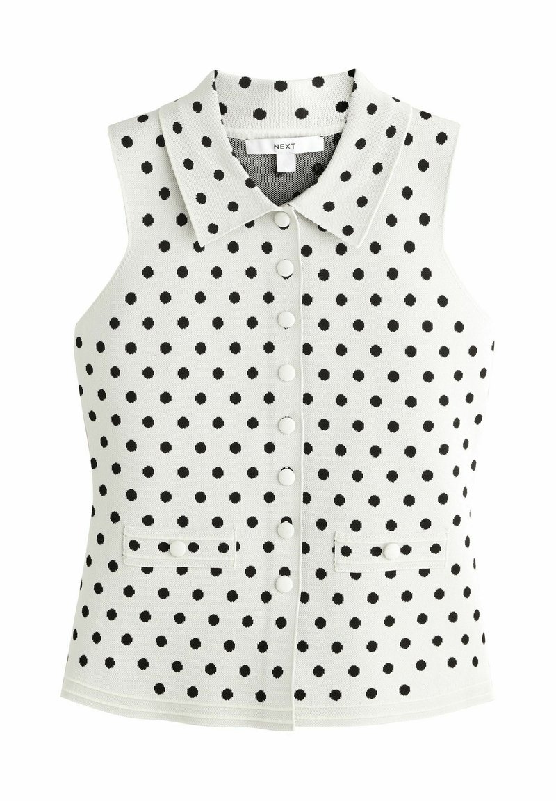 Ærmeløs vest i hvid med sorte polkaprikker, med krave, frontknapper og to små lommer ved taljen.