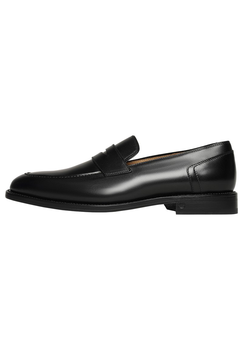 Des mocassins en cuir noir présentent un design épuré avec un bout rond et des coutures minimalistes, complétés par une semelle en caoutchouc basse.