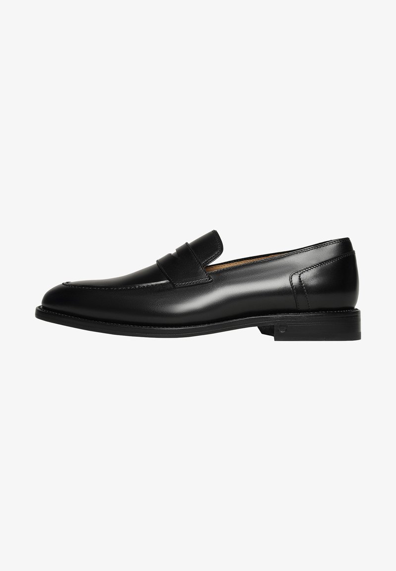 Des mocassins en cuir noir présentent un design épuré avec un bout rond et des coutures minimalistes, complétés par une semelle en caoutchouc basse.