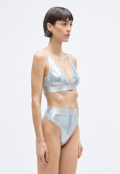 Ezüst metál bikini szett mély V-nyakú bralette-tel és magas derekú bugyival, amely texturált logószalagot tartalmaz. Sima, fényvisszaverő anyag.