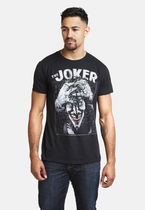 Black cotton t-shirt with a Joker graphic design, featuring vibrant colors, intricate details, and a crew neck style.