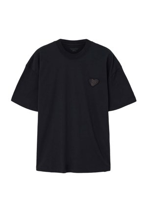 Zwart katoenen T-shirt met korte mouwen en een ronde hals. Heeft een klein zwarte hartafbeelding op de linkerborst.