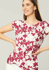 Bloem T-shirt in wit en dieproze met korte mouwen, ronde halslijn, geplooide details aan de zijkanten en een ontspannen pasvorm.