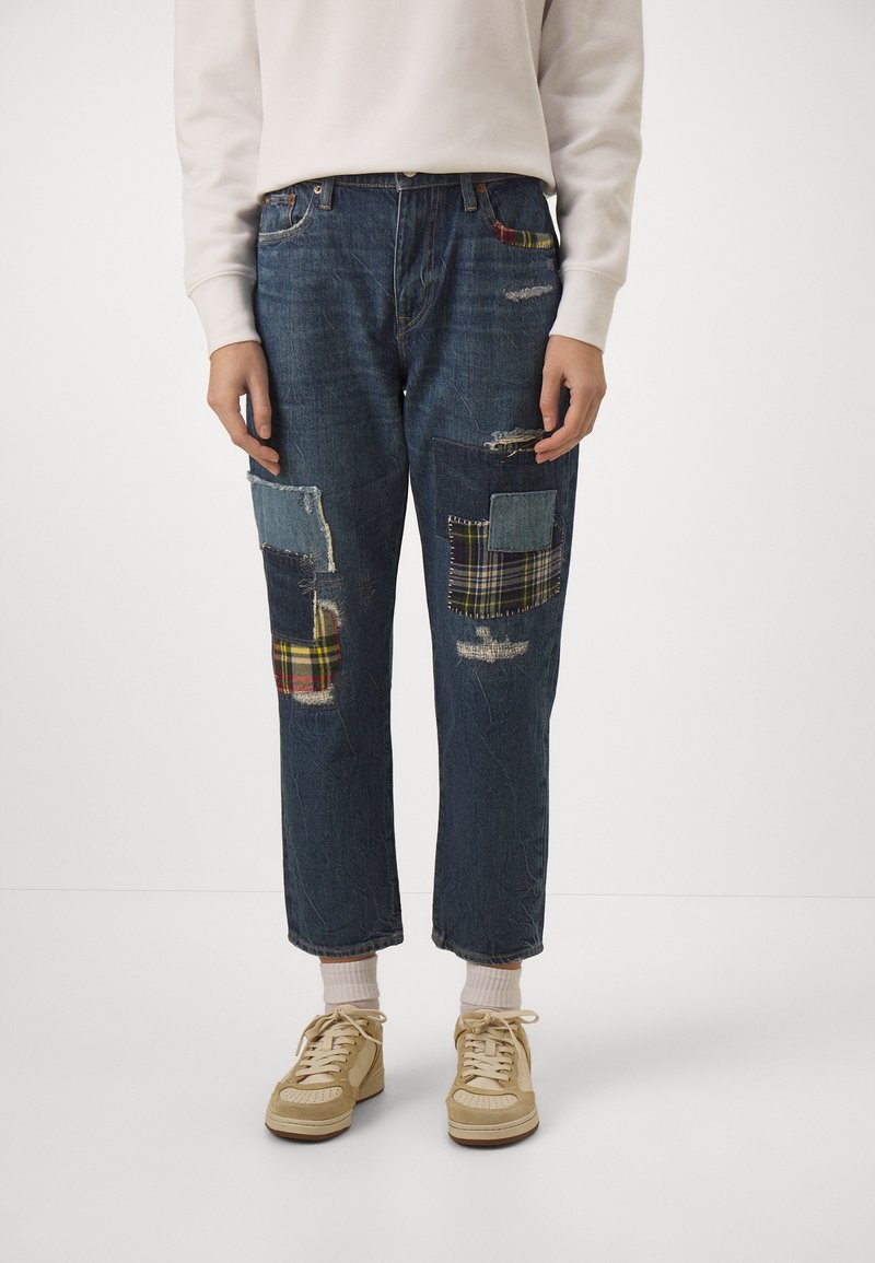 Denimjeans med en mörkblå tvätt, med patchworkdetaljer i rutigt och olika denimtexturer, slitna områden och en avslappnad passform.
