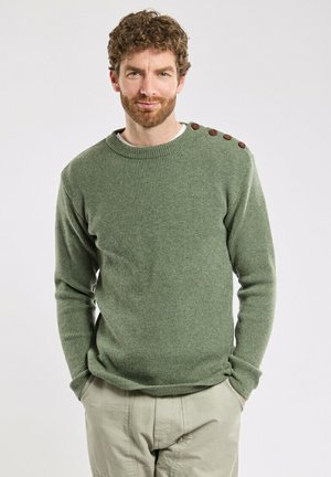 Maglione verde a costine con collo rotondo e quattro bottoni di legno sulla spalla. Texture morbida, maniche aderenti e design informale.