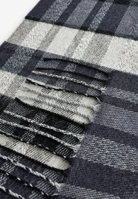 Gewebter Schal mit einem karierter Muster in Schwarz, Grau und Weiß. Verfügt über fransige Kanten und eine weiche, strukturierte Optik.
