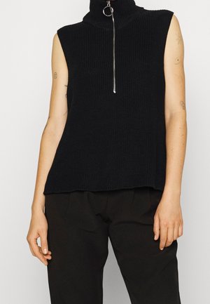 Schwarzes ärmelloses Turtleneck-Oberteil aus geripptem Strickstoff mit einem silbernen Reißverschluss und einer lockeren Passform am Saum.