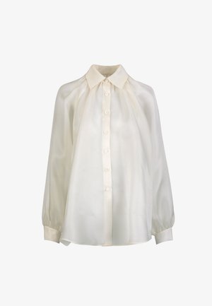 Blusa de manga larga color crema con cierre de botones en la parte delantera, cuello puntiagudo, hombros fruncidos y mangas con puños.