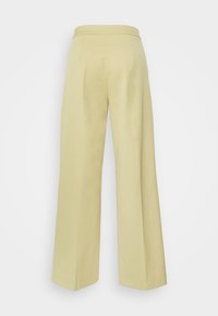 Calças largas em tecido amarelo claro. Apresentam uma cintura suave e linhas limpas, sem bolsos ou fechos visíveis.