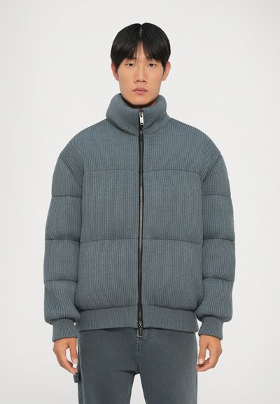 Graue Steppjacke mit hohem Kragen, Reißverschluss vorne und gerippter Textur. Verfügt über horizontale Nähte und eng anliegende Bündchen.
