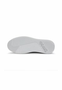 White rubber sneaker sole with ridged pattern, featuring logo detail. The surface shows textured grip for traction.