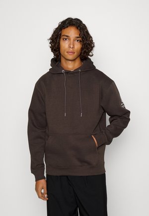 Brauner Hoodie aus weichem Stoff, ausgestattet mit einer Kapuze mit Kordelzug, einer Vordertasche und gerippten Bündchen. Einfaches Design ohne sichtbare Muster oder Logos.