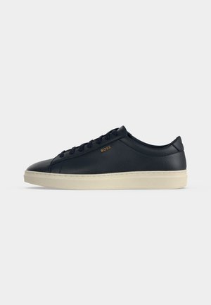 Baskets basses en cuir bleu marine avec semelle en caoutchouc crème et marquage "BOSS" doré sur le côté, vues de côté.