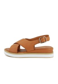 Sandali in pelle tan con punta aperta, design a strappo incrociato, fibbia per caviglia regolabile e suola intermedia bianca. Suola piatta e confortevole.