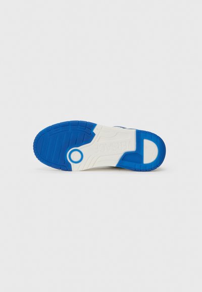 Sole di sneakers in gomma blu e bianca con superficie texture, caratterizzata da un accento circolare e modelli distintivi per la trazione.