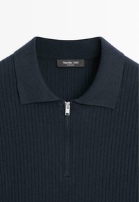 Granatowa prążkowana dzianinowa koszulka polo z srebrnym, półzamkiem i kołnierzykiem, z widoczną metką Massimo Dutti wewnątrz kołnierza.