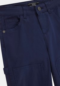 Pantaloni in tessuto blu navy con tasche frontali, chiusura a bottone e cuciture visibili. Presentano un design pulito con una vestibilità standard.