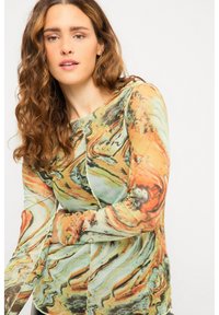 Langärmliges Oberteil mit einem marmorierten Muster in Grüntönen, Orange und Creme. Hergestellt aus einem leichten, strukturierten Stoff.