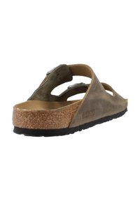 Sandalo Birkenstock marrone con fondo in sughero, tomaia in pelle, fibbia regolabile e suola testurizzata. Design aperto con più ritagli.