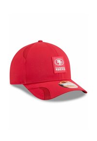 Casquette de baseball rouge avec un design structuré, dotée de panneaux en maille, d'une patch à l'avant affichant le logo des San Francisco 49ers, et d'un bord incurvé.