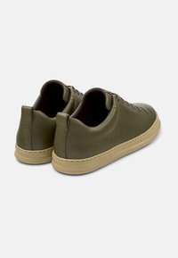 Gröna lädersneakers med en slät yta, rund tå och minimalistisk design. Har beige gummisulor och subtila perforeringar.