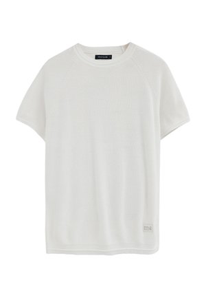 T-shirt bianca a maniche corte in maglia con scollo rotondo e piccola etichetta "Polo Club" vicino all'orlo sul davanti.